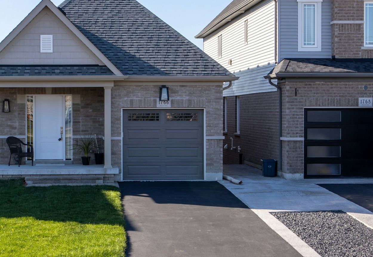 Suburban brick home with a gray sectional garage door and driveway